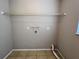 A well lit laundry room with tile flooring and a wire shelf overhead at 21 Pecan Course Cir, Ocala, FL 34472