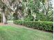 Lush backyard with manicured hedges, mature trees, and a well-maintained lawn at 231 Ne 28Th Ave # 207, Ocala, FL 34470