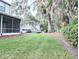 Spacious backyard featuring mature trees, a well-maintained lawn, and a screened porch at 231 Ne 28Th Ave # 207, Ocala, FL 34470