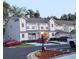Exterior view of a well-maintained townhome complex with manicured landscaping and multiple parked cars at 231 Ne 28Th Ave # 207, Ocala, FL 34470