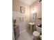 Cozy powder room with pedestal sink, decorative mirror and cabinet, and light neutral colors at 231 Ne 28Th Ave # 207, Ocala, FL 34470