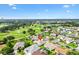 Scenic aerial view of homes near a well-maintained golf course, complemented by clear skies at 3141 Roswell Rd, The Villages, FL 32162