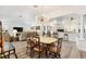 Open-concept dining room and living area with stylish light fixture, wood floors and bar access at 3141 Roswell Rd, The Villages, FL 32162