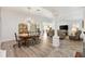 Open-concept dining room and living area with stylish light fixture, wood floors and plenty of natural light at 3141 Roswell Rd, The Villages, FL 32162