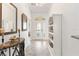 Elegant foyer with tiled floors, decorative shelving, and a glass-paneled front door at 3141 Roswell Rd, The Villages, FL 32162