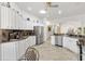 Bright kitchen featuring stainless appliances, custom cabinets, granite countertops, and tile flooring at 3141 Roswell Rd, The Villages, FL 32162