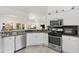 Kitchen features granite countertops, stainless steel appliances, white cabinets, and tile flooring at 3141 Roswell Rd, The Villages, FL 32162