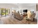 Open-concept living room features wood floors, a large tv, and sliding doors at 3141 Roswell Rd, The Villages, FL 32162