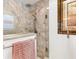 Modern shower with a frameless glass door, stone tile walls, and a rainfall showerhead, exuding spa-like luxury at 3141 Roswell Rd, The Villages, FL 32162