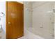 Bathtub with tile surround, door to the bathroom, and showerhead in a bright, clean space at 3295 Se 56 Ave, Ocala, FL 34480