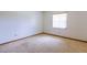 An empty bedroom with carpet flooring, white walls, and a single window at 3295 Se 56 Ave, Ocala, FL 34480