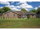 Charming single-story brick home with a well-manicured lawn and blue skies at 3295 Se 56 Ave, Ocala, FL 34480