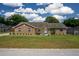 Single-story brick home with manicured landscaping, healthy green lawn, and a cloudy sky at 3295 Se 56 Ave, Ocala, FL 34480
