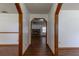 Hallway with wood-look flooring leads to a living room with brick fireplace and windows at 3295 Se 56 Ave, Ocala, FL 34480