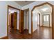 Open hallway featuring hardwood floors, white walls, and multiple closet doors at 3295 Se 56 Ave, Ocala, FL 34480