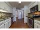 Bright kitchen features white cabinetry, stainless appliances, mosaic backsplash, and wood-look flooring throughout at 3295 Se 56 Ave, Ocala, FL 34480