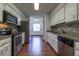Galley kitchen featuring stainless steel appliances, mosaic backsplash and white cabinetry at 3295 Se 56 Ave, Ocala, FL 34480
