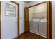 Laundry room featuring white washer and dryer, wood-look flooring, and access to exterior at 3295 Se 56 Ave, Ocala, FL 34480