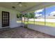 Spacious screened porch showcasing decorative tile floors, white walls, and a wooden door at 3295 Se 56 Ave, Ocala, FL 34480