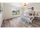 Serene bedroom featuring a large window, neutral decor and wood-look flooring at 346 Emerald Rd, Ocala, FL 34472