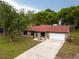 View of the house featuring a well-manicured lawn, long driveway, and a two-car garage at 346 Emerald Rd, Ocala, FL 34472