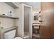 Cozy bathroom showcases a tiled stand-up shower, toilet, sink, vanity, open shelving, and charming rustic decor at 3823 Se 49Th St, Ocala, FL 34480