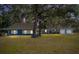 Charming blue single-story home featuring a well-manicured lawn and mature shade trees at 3823 Se 49Th St, Ocala, FL 34480
