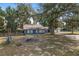Charming blue home featuring a fire pit and a sprawling yard with mature trees and a detached two-car garage at 3823 Se 49Th St, Ocala, FL 34480