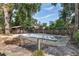 An in-ground pool surrounded by greenery and several outbuildings at 3823 Se 49Th St, Ocala, FL 34480