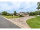 Paver driveway leading to a well-maintained home with lush landscaping and mature trees at 4015 Se 22Nd St, Ocala, FL 34471