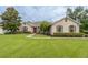 Charming single-story home featuring manicured lawn, stone accents, and a vibrant red front door at 4015 Se 22Nd St, Ocala, FL 34471