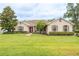 Charming single-story home featuring manicured lawn, stone accents, and a vibrant red front door at 4015 Se 22Nd St, Ocala, FL 34471