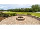Brick fire pit and patio surrounded by greenery, offering a private outdoor space at 4015 Se 22Nd St, Ocala, FL 34471