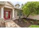 Inviting front entrance with a vibrant red door, stone accents, and lush landscaping at 4015 Se 22Nd St, Ocala, FL 34471