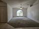 View of the living room featuring carpet flooring, large arched window, and neutral color palette at 4460 Sw 44Th St, Ocala, FL 34474
