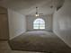 Large open concept living room featuring a ceiling fan, carpeted floors, and a large arched window at 4460 Sw 44Th St, Ocala, FL 34474