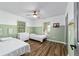 Bright bedroom with wood-look floors, ceiling fan, and two twin beds at 4601 Se 18Th Ave, Ocala, FL 34480