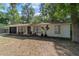 Single story home features stone details, mature landscaping, black garage door, and black framed windows at 4601 Se 18Th Ave, Ocala, FL 34480
