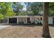 Charming single-story home with a brick facade, a black garage door, and a well-manicured front yard at 4601 Se 18Th Ave, Ocala, FL 34480
