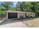 Single story home shows stone details, black garage door, black trimmed windows and mature landscaping at 4601 Se 18Th Ave, Ocala, FL 34480