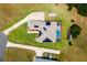 Aerial view of a home with a solar panel roof, screened pool, adjacent garden, and a long driveway at 5815 Ne 70Th St, Silver Springs, FL 34488