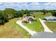 Expansive property featuring a tan home with solar panels, a long driveway, mature trees, and lush green lawn at 5815 Ne 70Th St, Silver Springs, FL 34488