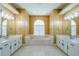 Bathroom featuring double vanities, a large soaking tub under a window, and tile flooring at 5815 Ne 70Th St, Silver Springs, FL 34488