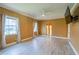 Spacious bedroom with wood-look tile flooring, a ceiling fan, and large windows dressed with white curtains at 5815 Ne 70Th St, Silver Springs, FL 34488