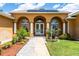 Close-up of a home's entryway with white pillars, arched windows, solar panels and manicured landscaping at 5815 Ne 70Th St, Silver Springs, FL 34488