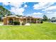 Inviting tan stucco home with well-kept lawn, front yard landscaping, solar panels, and arched windows at 5815 Ne 70Th St, Silver Springs, FL 34488