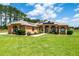 Attractive tan home with solar panels, a well-manicured lawn, arched windows, and lush landscaping at 5815 Ne 70Th St, Silver Springs, FL 34488