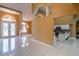 Open-concept living area featuring tile floors, an arched doorway, and a glimpse into the kitchen with stainless steel appliances at 5815 Ne 70Th St, Silver Springs, FL 34488