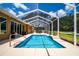 Screened-in pool featuring waterfall and hot tub, well-manicured landscape, perfect for enjoying the outdoors at 5815 Ne 70Th St, Silver Springs, FL 34488