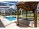 This backyard offers a covered, screened-in inground pool with a grilling and entertaining area at 5815 Ne 70Th St, Silver Springs, FL 34488
